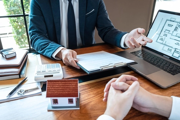 conversing with paper and laptop on table -real estate consulting